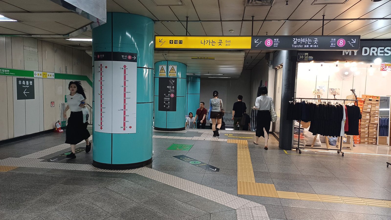 잠실역 환승통로. 승객들이 두 노선 사이를 걸어서 이동하고 있다