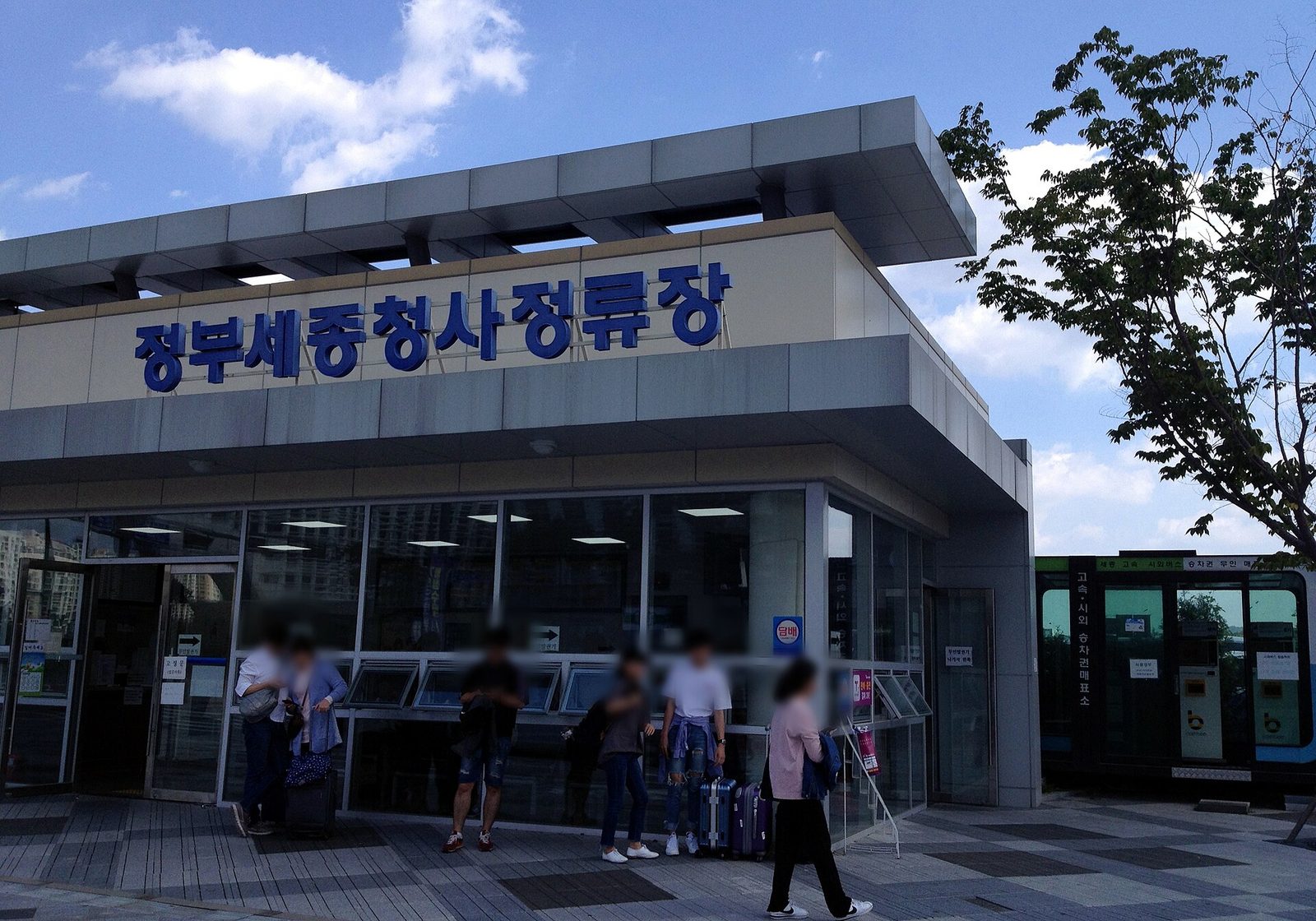 정부세종청사 고속시외버스정류장 앞. 여행가방을 끌고 이동하는 사람들이 보인다