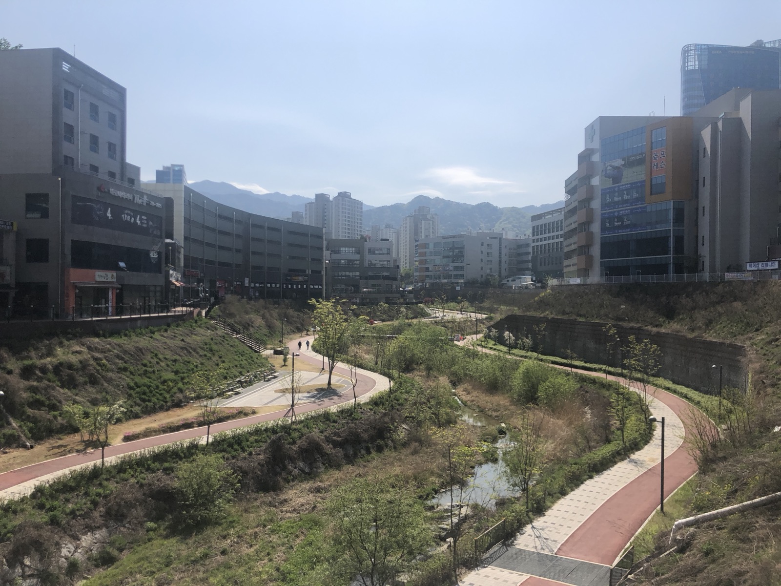 원주혁신도시 하천변에 조성된 보행로와 자전거길, 그 양옆의 상가 건물